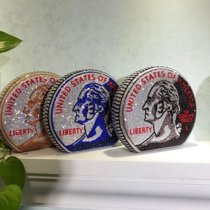 Close-up of circular dollar coin clutch bags featuring intricate rhinestone encrusting
