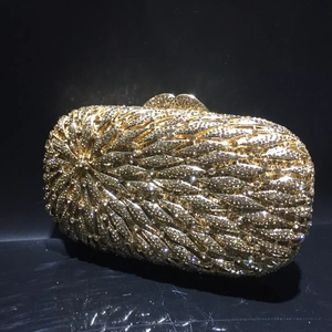 Détail de la pochette de soirée dorée avec motif de plumes en strass étincelants