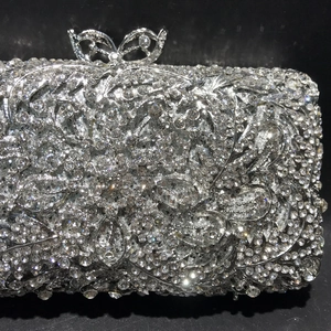 Detail of silver evening clutch with floral crystal patterns and bow-shaped clasp