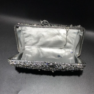 Detail view of silver crystal clutch bag showing interior capacity with a metal chain strap
