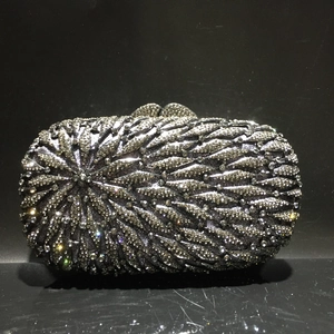 Gros plan d'une pochette de soirée argentée avec motif de plumes en strass étincelants