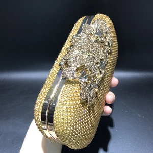 Detail of gold evening clutch bag with sparkling rhinestone floral pattern decoration