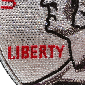 Macro shot of sparkling rhinestones spelling LIBERTY on a silver evening handbag