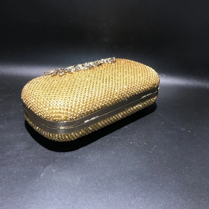 Close-up of the golden flower clasp and sparkling crystal surface on the evening clutch bag