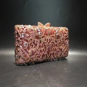 Detailed view of pink floral rhinestone patterns and bow crystal clasp on evening clutch