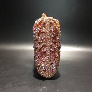 Detailed view of luxury pink and gold rhinestone encrusted hollow metal evening clutch bag