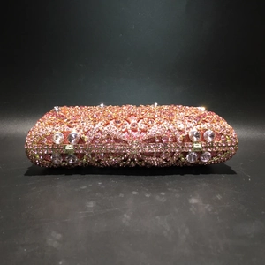 Detail of pink crystal rhinestones and metal hollow frame on the elegant evening clutch