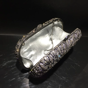 Détail d'une pochette de soirée avec motif géométrique en strass et chaîne métal