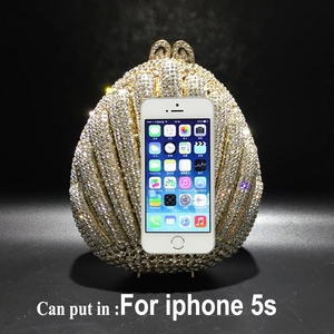 Shell shaped crystal evening clutch size comparison with a mobile phone for scale