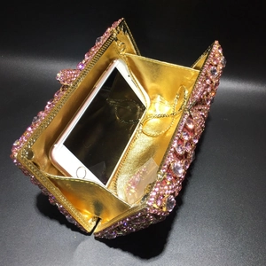 Detailed interior of pink rhinestone evening clutch showing phone capacity and chain strap