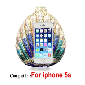 Detail showing shell-shaped evening bag capacity holding a smartphone and small items