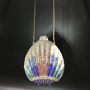 Close-up of shell-shaped evening bag with colorful crystals and gold chain strap