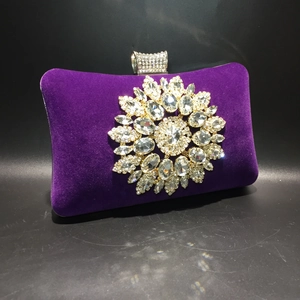 Detail of purple velvet evening clutch with sparkling rhinestone sunflower and crystal clasp