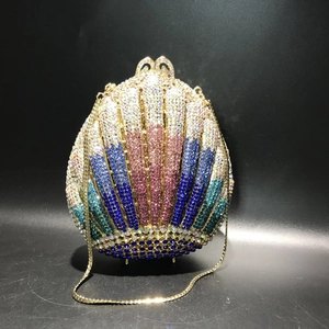 Detail of shell-shaped evening bag featuring colorful rhinestones and gold chain strap