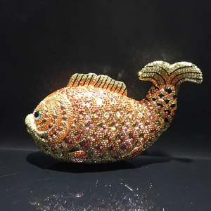 Detail of goldfish evening clutch bag with multicolored rhinestones and metallic fish tail