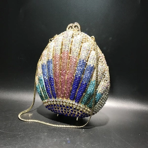Detailed view of a shell-shaped evening bag featuring colorful rhinestones and gold chain