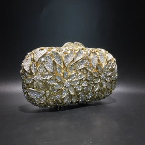 Close-up of luxury gold frame clutch bag with intricate silver rhinestone floral patterns