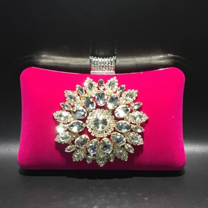 Close-up of fuchsia velvet evening bag with sparkling rhinestone flower and crystal clasp