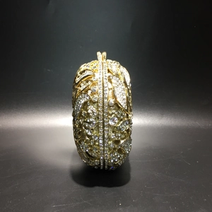 Detailed view of hollow gold metal frame and crystal rhinestones on the luxury evening clutch