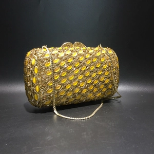Golden luxury evening clutch with yellow cat eye stones and butterfly clasp decoration