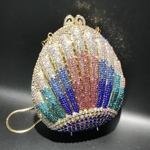 Detailed view of colorful rhinestones on shell-shaped evening bag with gold chain strap