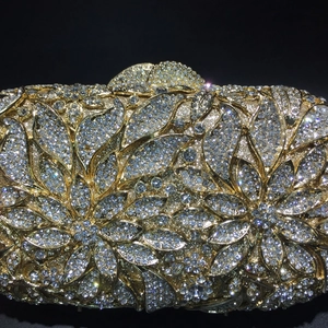 Golden hollow metal evening clutch with full crystal floral patterns on black background