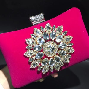 Macro detail of fuchsia velvet evening bag with crystal sunflower ornament and clasp