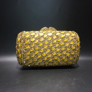 Gold metal clutch bag with yellow rhinestones, cat eye stones and heart clasp