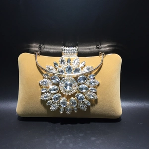 Detailed close-up of crystal sunflower decoration on velvet evening clutch handbag