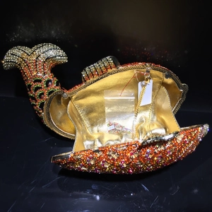 Detail view of fish shaped clutch with orange and yellow rhinestones and gold chain strap