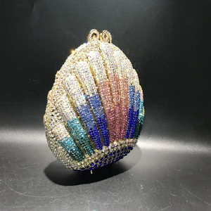 Macro detail of shell-shaped evening bag with gradient multicolored rhinestones and gold clasp