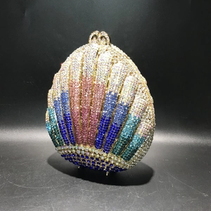 Macro view of shell-shaped evening bag featuring gradient rhinestones and gold frame