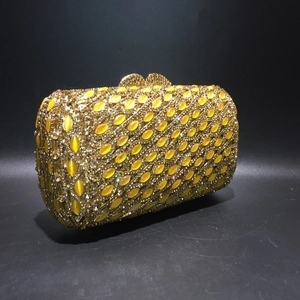 Elegant gold metal evening clutch bag encrusted with crystals and yellow cat-eye stones