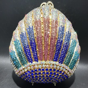 Detail of shell-shaped evening clutch featuring multi-color gradient crystals and metal frame
