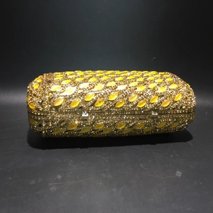 Detailed close-up of golden crystal evening clutch featuring yellow teardrop gemstone texture