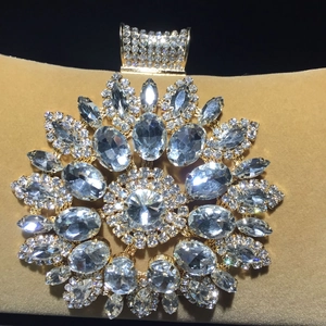 Macro detail of luxury sunflower crystal buckle with gold base and sparkling rhinestones