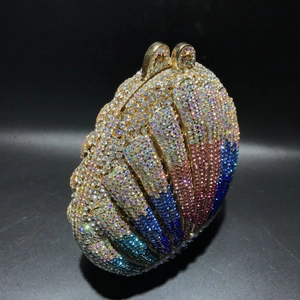 Macro detail of luxury gradient crystal shell clutch bag with gold-tone metal frame