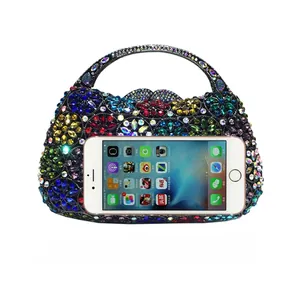 Detailansicht zum Größenvergleich der floralen Strass-Abendtasche mit einem Smartphone