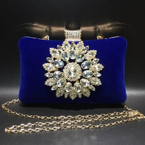Macro detail of royal blue velvet evening bag with large sparkling sunflower rhinestone