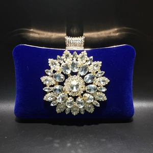 Macro detail of royal blue velvet clutch with crystal sunflower and jewel closure
