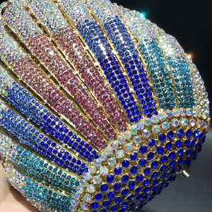 Macro shot of shell-shaped evening bag with colorful crystals and gold metal frame