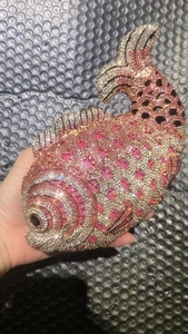 Detailed close-up of a luxury fish-shaped evening clutch bag encrusted with pink rhinestones
