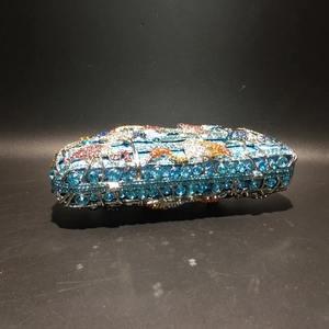 Détail de la pochette de soirée en strass bleus avec motif de flamant rose en cristal brillant