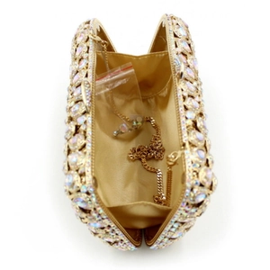 Detail of gold evening clutch bag interior with satin lining and detachable chain strap