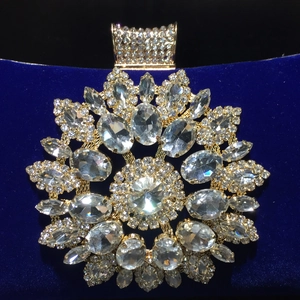 Close-up of sparkling sunflower crystal brooch on deep blue velvet evening bag