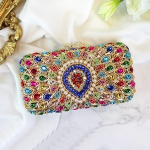 Detail of luxury evening clutch with colorful crystals, pearls and gold metal frame