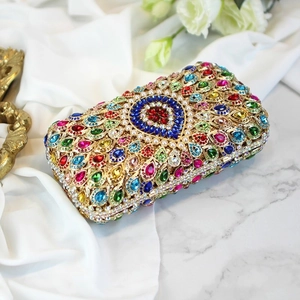 Macro shot of colorful rhinestones and pearls on a luxury gold metallic evening bag