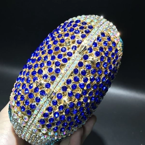 Close-up of shell-shaped evening clutch with dark blue crystals and gold metal frame
