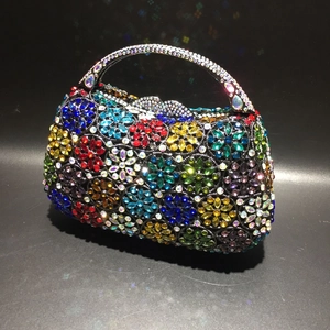 Detailansicht bunter Kristallblumenmuster und Metallgriff an der Abendhandtasche