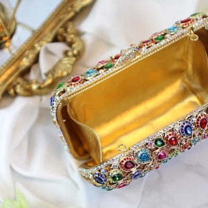 Close-up of golden evening clutch with colorful rhinestones and premium silk lining